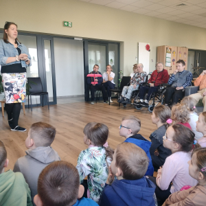 Pani Kierownik Magdalena Dobosz opowiada dzieciom o pracy Gminnego Centrum Opiekuńczo-Mieszkalnego w Górce. Kliknięcie na zdjęcie spowoduje jego powiększenie do rozmiaru oryginalnego.