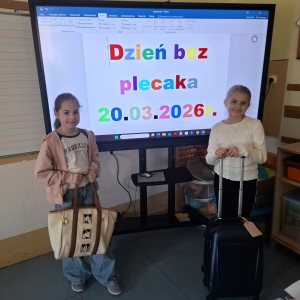 Dwie dziewczynki pokazują torbę i walizkę przyniesione zamiast plecaków z okazji powitania wiosny. Kliknięcie na zdjęcie spowoduje jego powiększenie do rozmiaru oryginalnego.