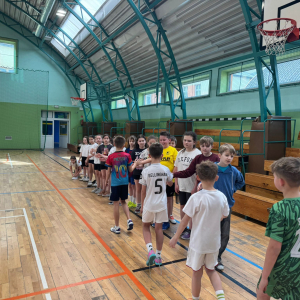 Uczniowie witają się na hali przed rozpoczęciem sportowej rywalizacji.  Kliknięcie na zdjęcie spowoduje jego powiększenie do rozmiaru oryginalnego.