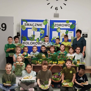 Klasa 1b wraz z wychowawczynią na tle gazetki promującej zdrowe odżywianie. Kliknięcie na zdjęcie spowoduje jego powiększenie do rozmiaru oryginalnego.