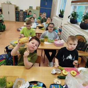 Uczniowie klasy 1 b siedzą w ławkach. Dzieci degustują zrobione przez siebie kanapki. Kliknięcie na zdjęcie spowoduje jego powiększenie do rozmiaru oryginalnego.