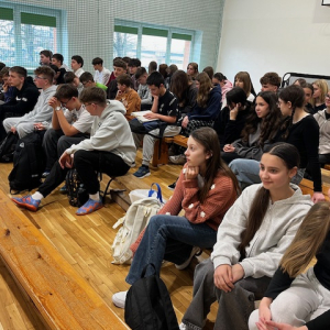 Uczniowie klas 7-8 zgormadzeni na sali gimnastycznej w czasie spotkania z policjantem. Kliknięcie na zdjęcie spowoduje jego powiększenie do rozmiaru oryginalnego.