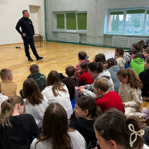 Policjant wygłasza prelekcję na temat cyberprzemocy do siedzących uczniów. Kliknięcie na zdjęcie spowoduje jego powiększenie do rozmiaru oryginalnego.
