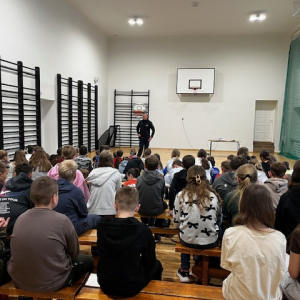 Młodzież słucha wykładu policjanta. Kliknięcie na zdjęcie spowoduje jego powiększenie do rozmiaru oryginalnego.