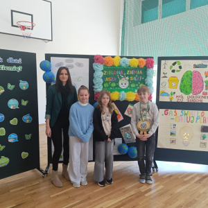 Pani Wicedyrektor Dorota Gurgul z grupką  uczniów klasy 4 b na uroczystości wręczania nagród z okazji obchodów Dnia Ziemi. Kliknięcie na zdjęcie spowoduje jego powiększenie do rozmiaru oryginalnego.