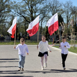 Grupka uczniów z klasy 3 b w trakcie biegu z flagami. Zdjęcia Urząd Gminy Szczurowa. Kliknięcie na zdjęcie spowoduje jego powiększenie do rozmiaru oryginalnego.
