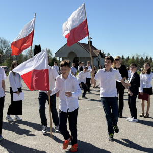 Uczniowie z klasy 7 b biegają z flagami po parkingu. Zdjęcia Urząd Gminy Szczurowa. Kliknięcie na zdjęcie spowoduje jego powiększenie do rozmiaru oryginalnego.