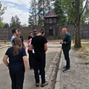 Przewodnik oprowadza uczniów po Nazistowskim Obozie Zagłady w Oświęcimiu. Kliknięcie na zdjęcie spowoduje jego powiększenie do rozmiaru oryginalnego.