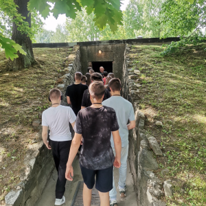 Ósmoklasiści wchodzą do jednego z pomieszczeń Nazistowskiego Obozu Zagłady w Oświęcimiu. Towarzyszy im przewodnik i nauczyciele. Kliknięcie na zdjęcie spowoduje jego powiększenie do rozmiaru oryginalnego.