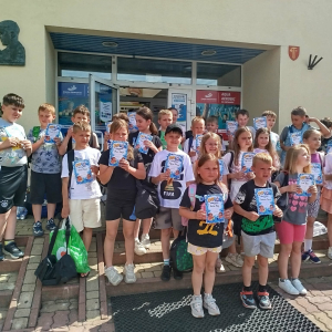 Grupa uczniów przed uczestniczących w ramach projektu "Już pływam" przed budynkiem basenu. Kliknięcie na zdjęcie spowoduje jego powiększenie do rozmiaru oryginalnego.