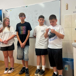 Grupka uczniów czasie czytania ćwiczeń przygotowanych przez pedagoga i psychologa w ramach Tygodnia Bezpieczeństwa. Kliknięcie na zdjęcie spowoduje jego powiększenie do rozmiaru oryginalnego.