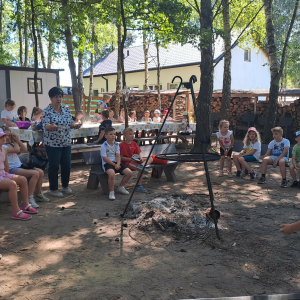 Nauczyciele wraz z uczniami smażą kiełbaski na grillu. Kliknięcie na zdjęcie spowoduje jego powiększenie do rozmiaru oryginalnego.