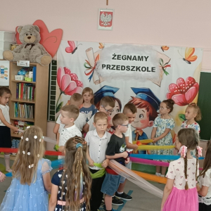 Przedszkolaki tańczą na zakończeniu roku przedszkolnego z kolorowymi chustami. Kliknięcie na zdjęcie spowoduje jego powiększenie do rozmiaru oryginalnego.