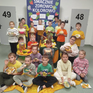 Klasa 2 b wraz z wychowawczynią na tle gazetki: "Smacznie-zdrowo-kolorowo". Kliknięcie na zdjęcie spowoduje jego powiększenie do rozmiaru oryginalnego.